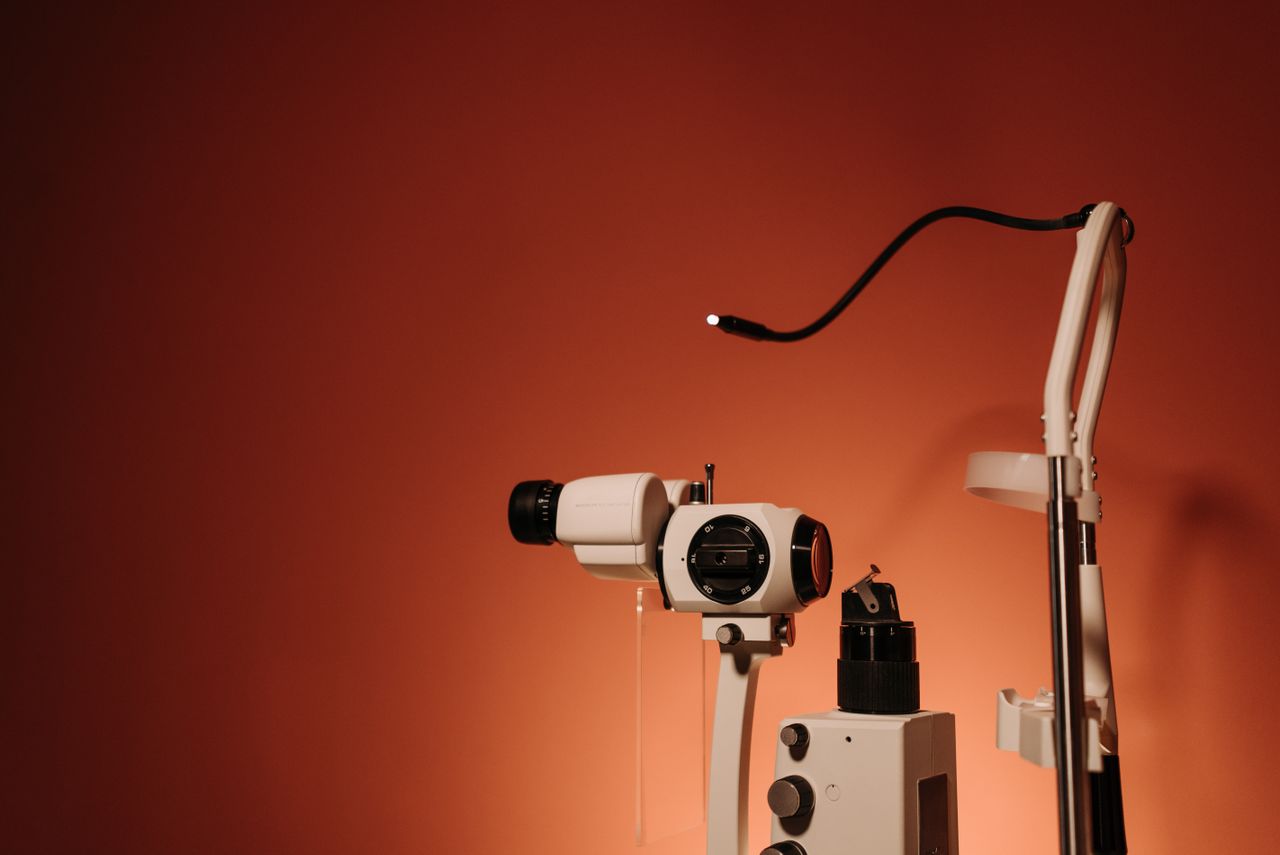 A slit lamp with fine optics on a brown background, ideal for healthcare promotions.